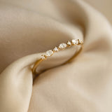 Marquise and Round Diamond Ring 14k Gold - Nova with three marquise cut and round diamonds on gold band on beige fabric background