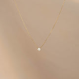 Diamond Pendant Necklace 14k Gold - Johanne with a delicate chain and a single floating diamond on beige background