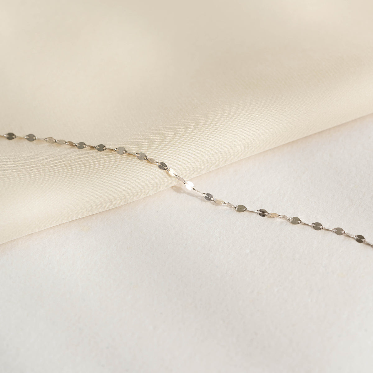 Close-up of Petal Chain Bracelet White Gold - Florence with delicate petal-shaped links on a soft neutral background