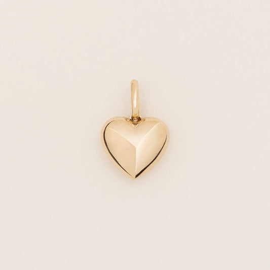 Yellow Gold heart-shaped pendant with a faceted geometric design and polished finish, shown against a light neutral background.