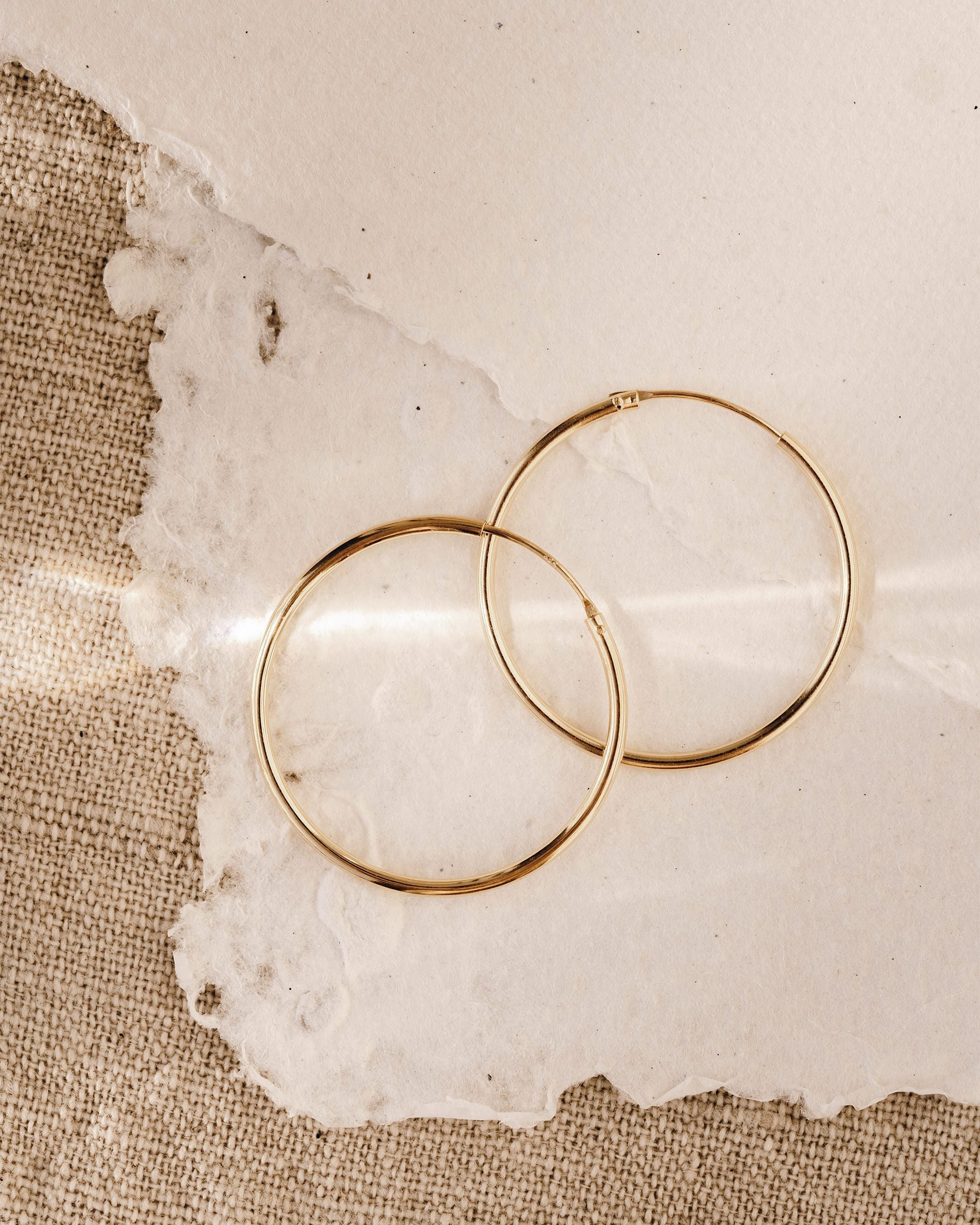 Thin large solid gold hoops with a hinged back