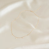 Pear Cut Diamond Pendant Necklace 14k Gold - Sylvie laid flat on cream fabric background in soft light