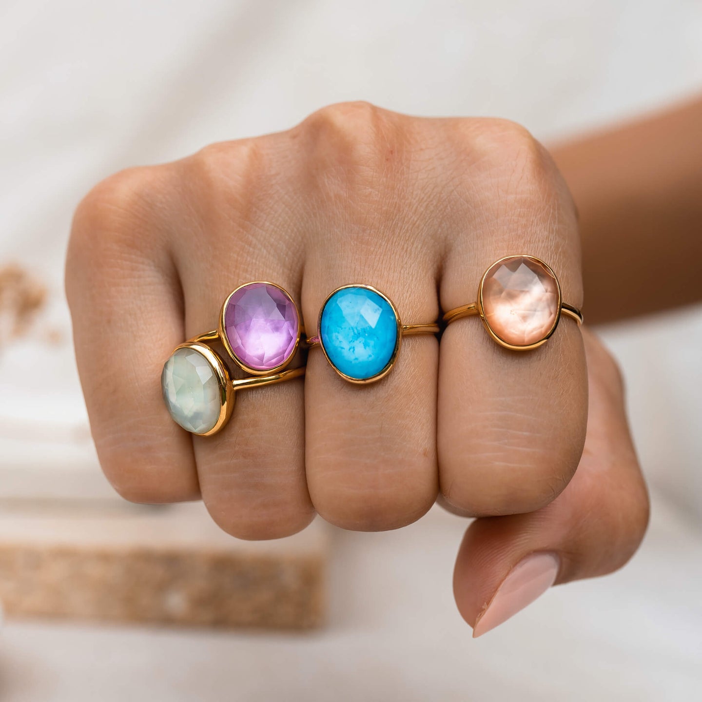 Four gemstone double rings in bezel setting stacked on model
