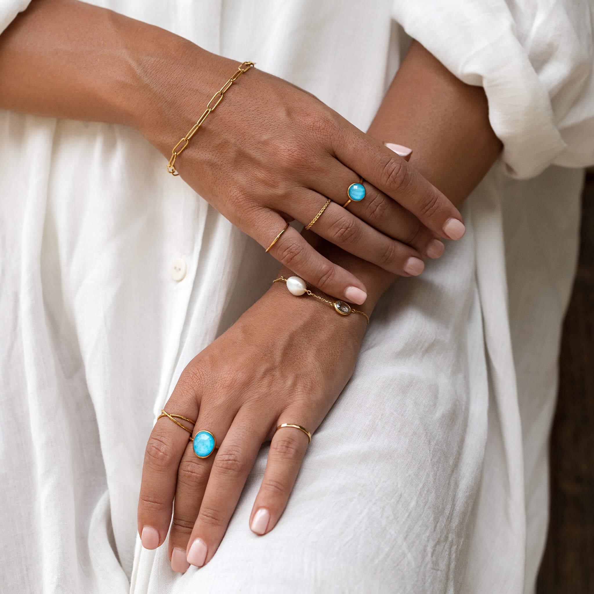 Gold bezel-set gemstone statement ring in amalfi blue on model