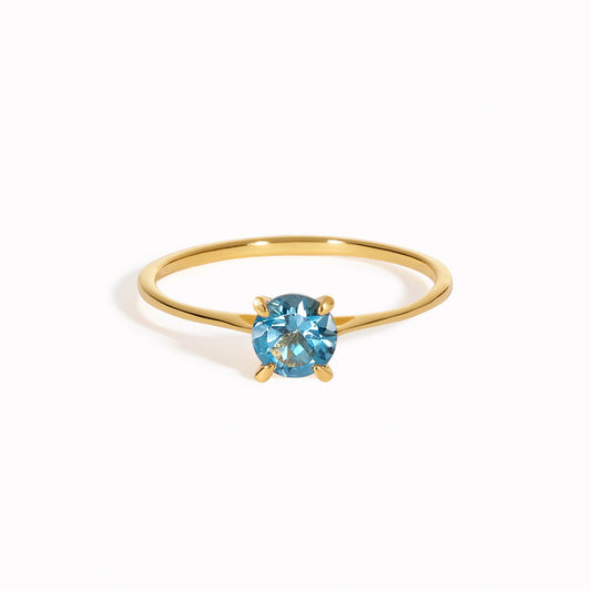 Round london blue topaz solitaire ring on a gold band