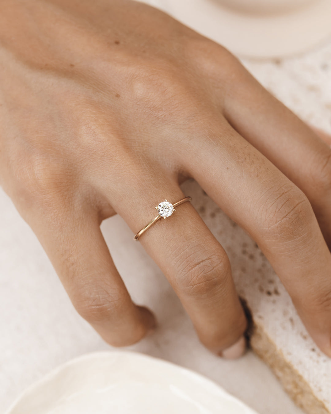 Round lab grown diamond on a 14k yellow gold band on hand