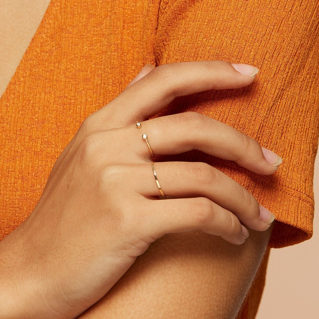 Two stacking rings on model with thin solid gold band and diamond open ring