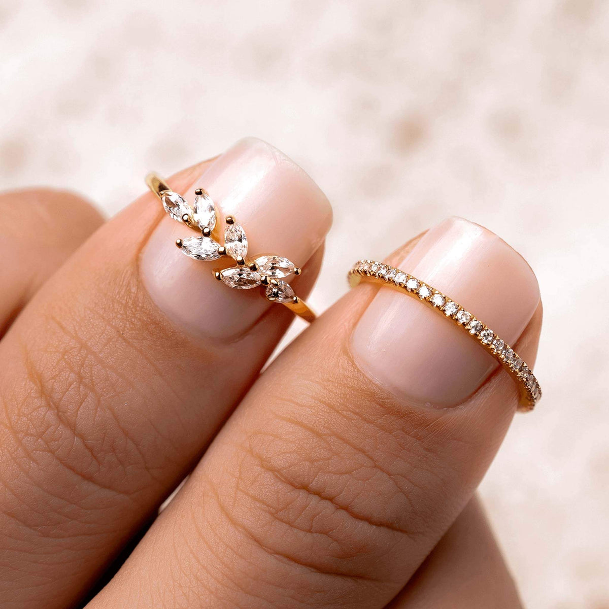 Two white gemstone rings made of gold vermeil on hand 