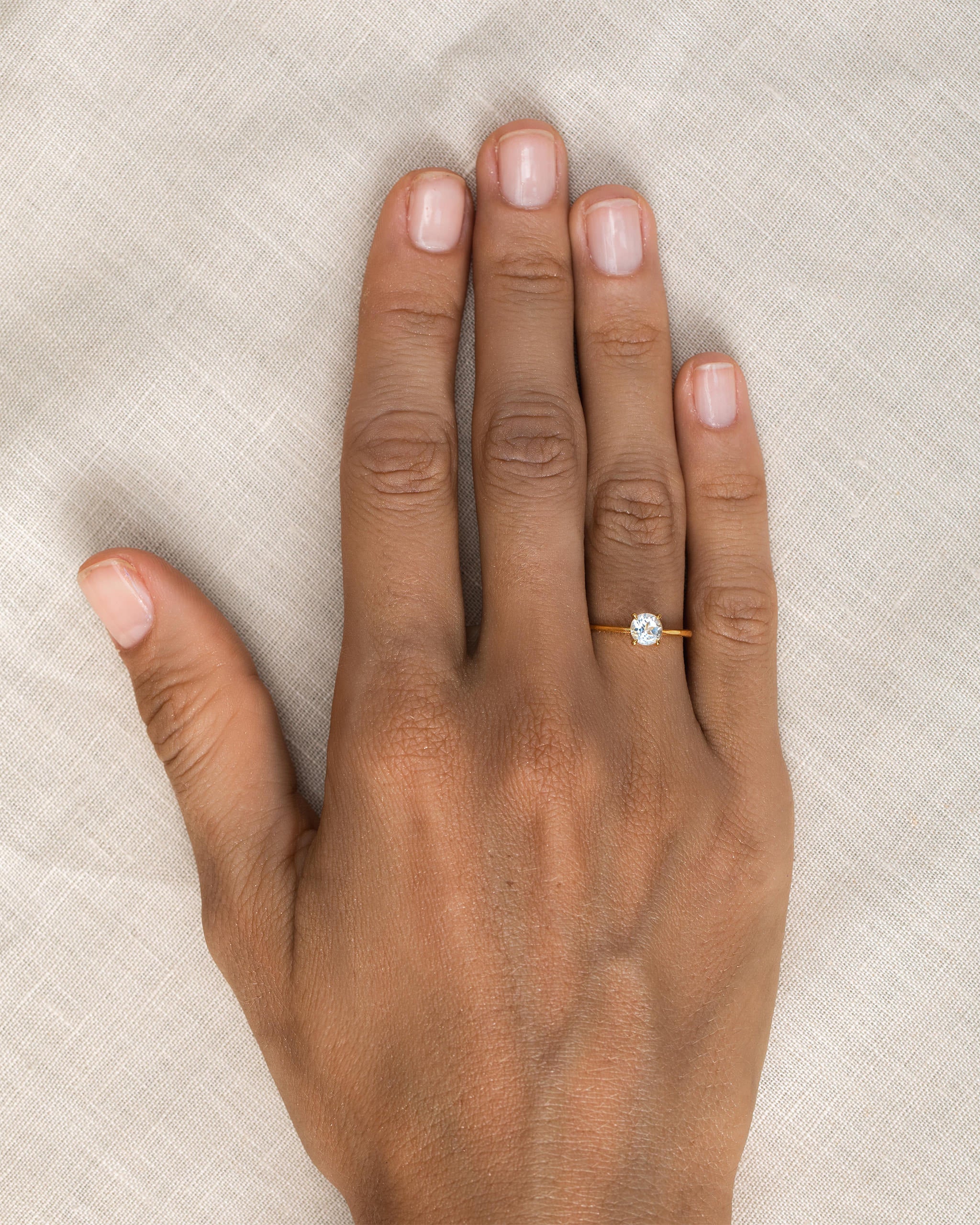 White topaz ring on gold vermeil band on hand