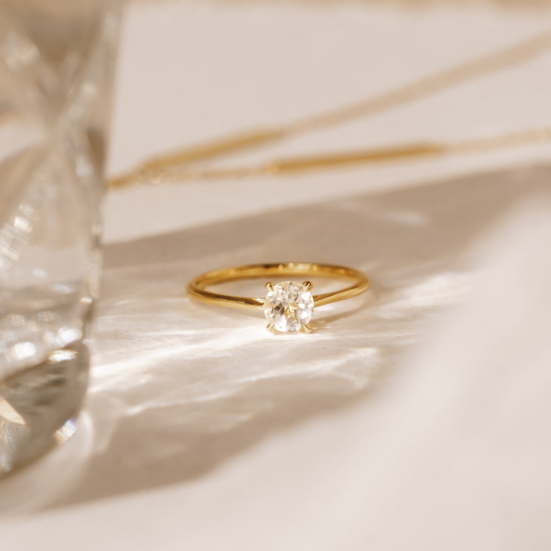 Round white topaz solitaire ring on gold band