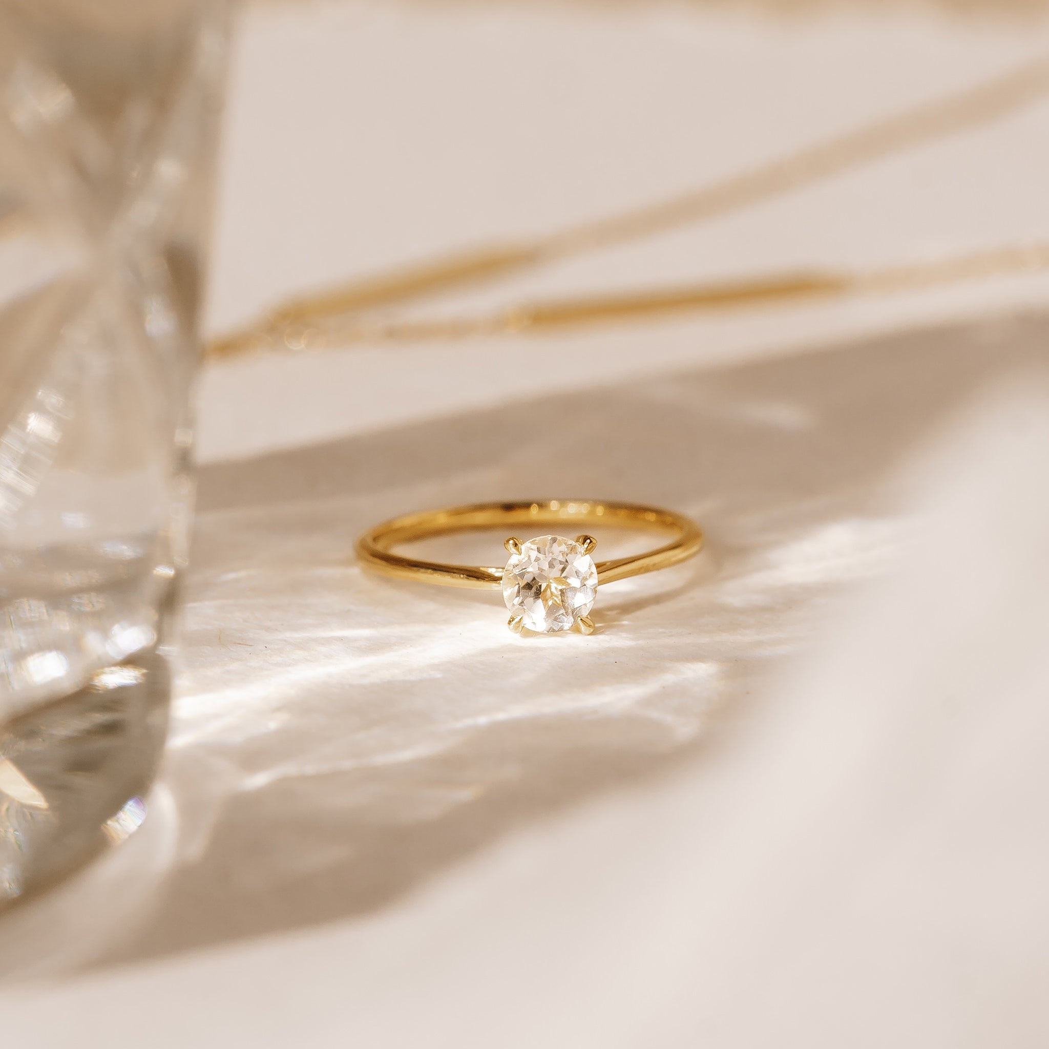 Round white topaz solitaire ring on gold band