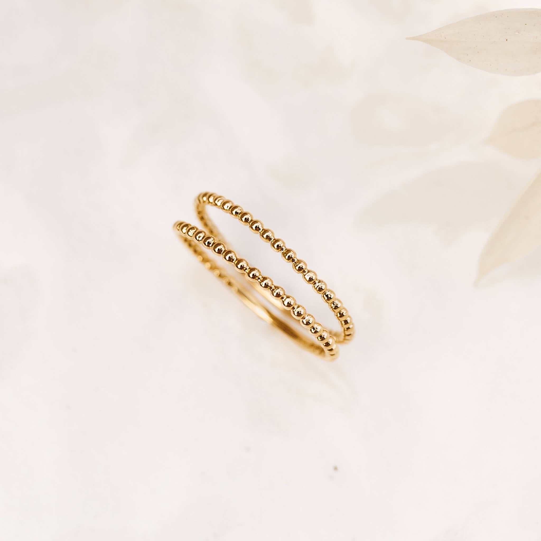 Two gold rings with beaded design