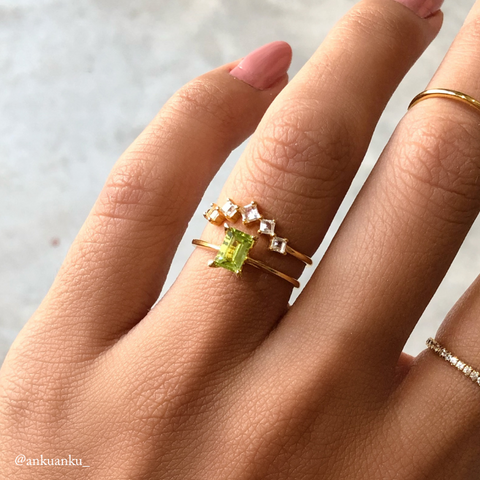 Peridot ring and white topaz ring in gold vermeil on finger