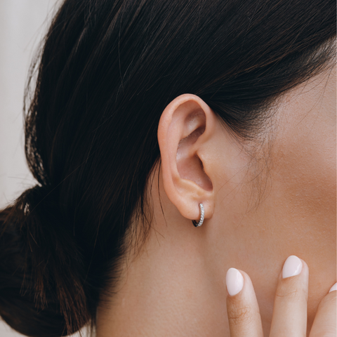 Eva Silver Huggie Hoop Earrings on ear