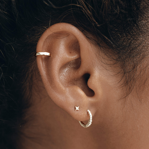 Ear cuff, star stud earring and huggie hoop earring in sterling silver on ear