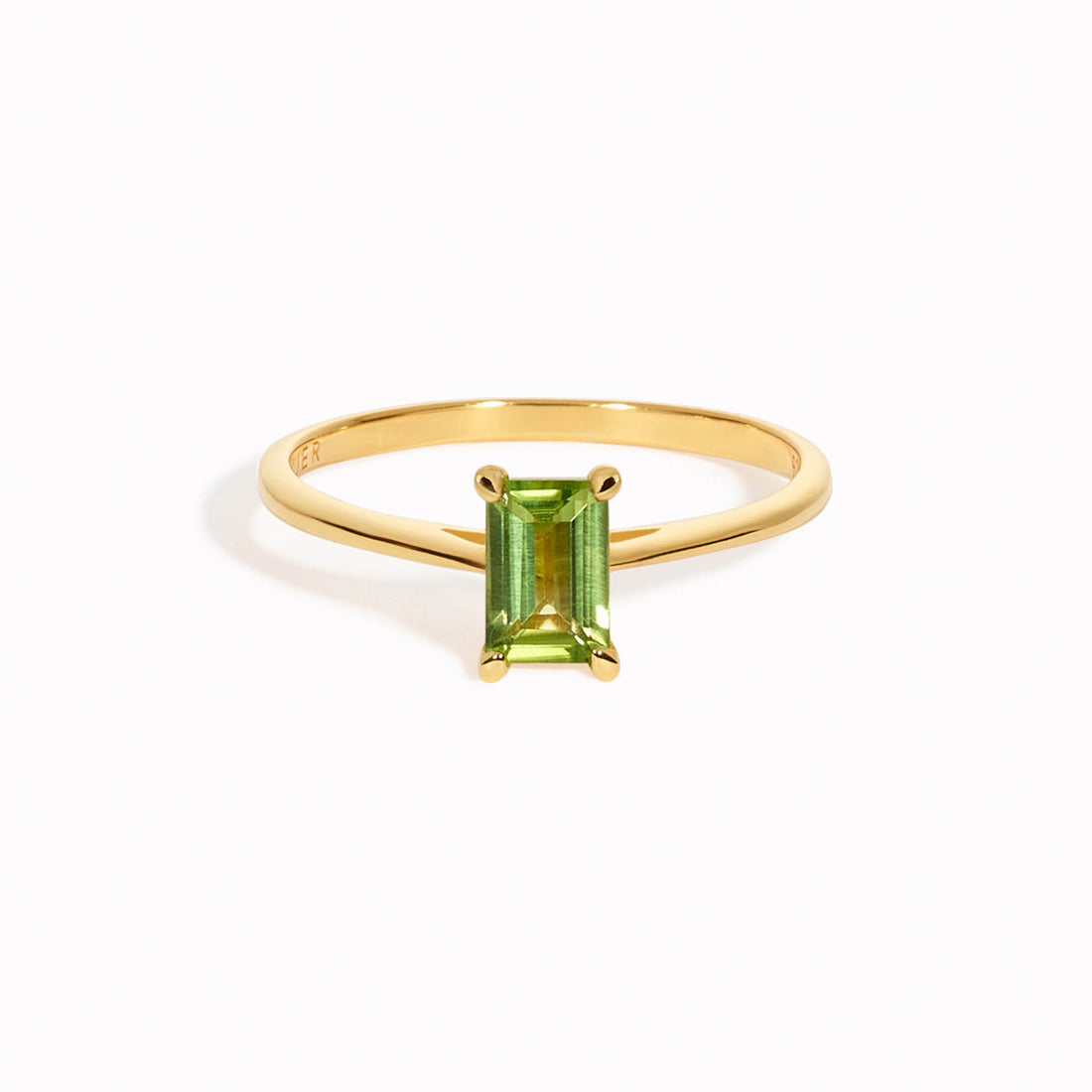 A gold ring with a baguette cut gemstone